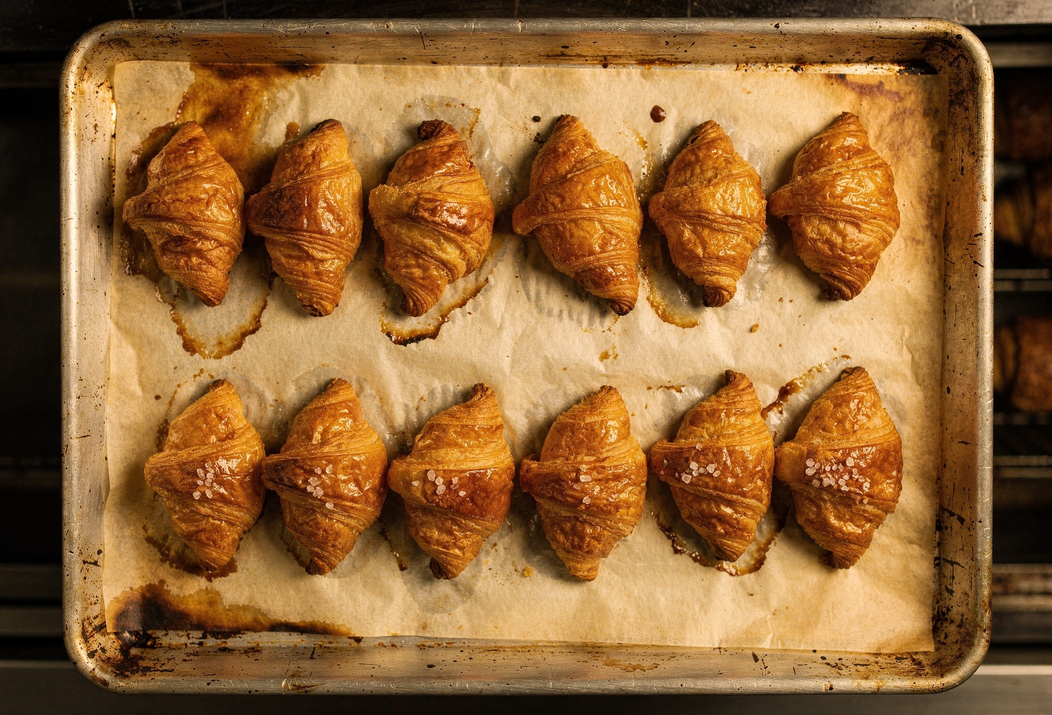 Fırın tepsisinde sıralı on taze pişmiş tereyağlı kruasan